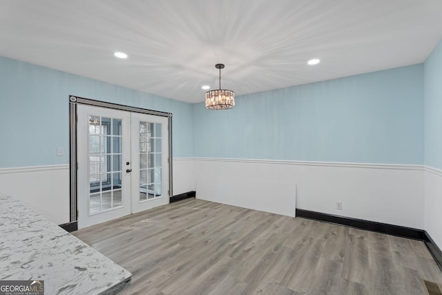 unfurnished dining area with recessed lighting, visible vents, wood finished floors, and french doors