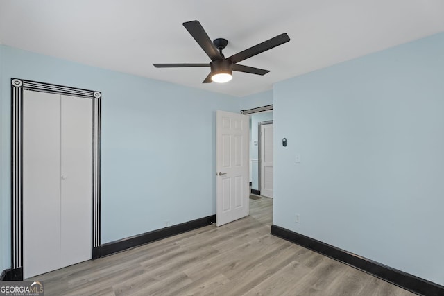 unfurnished bedroom featuring light wood-style flooring, baseboards, and ceiling fan