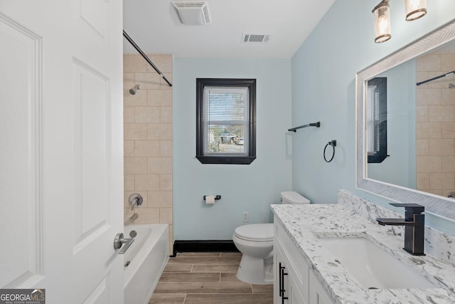 full bath featuring toilet, vanity, baseboards, visible vents, and wood tiled floor