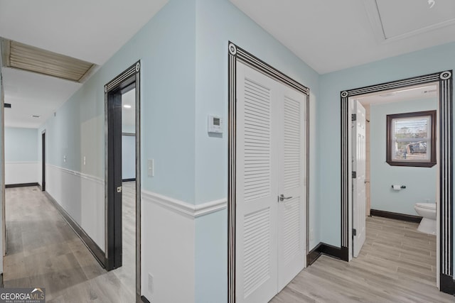 corridor with light wood finished floors and baseboards