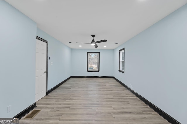 empty room featuring visible vents, ceiling fan, light wood-style flooring, and baseboards