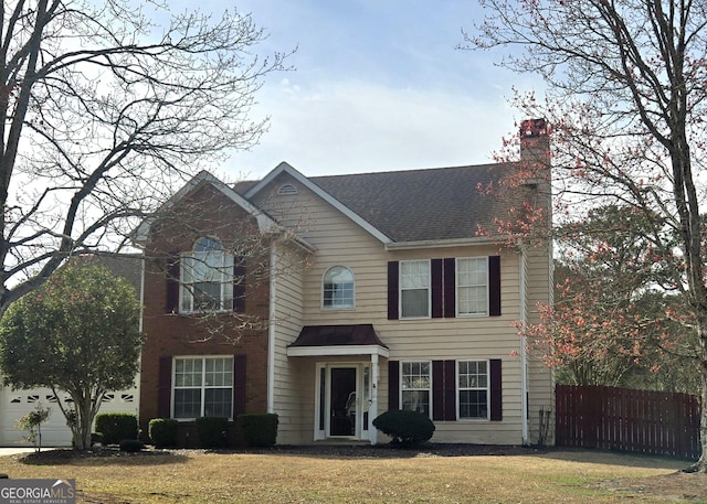 view of front facade with a front lawn, fence, and a chimney