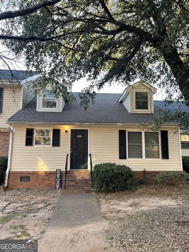 view of front facade featuring a shingled roof, entry steps, and crawl space