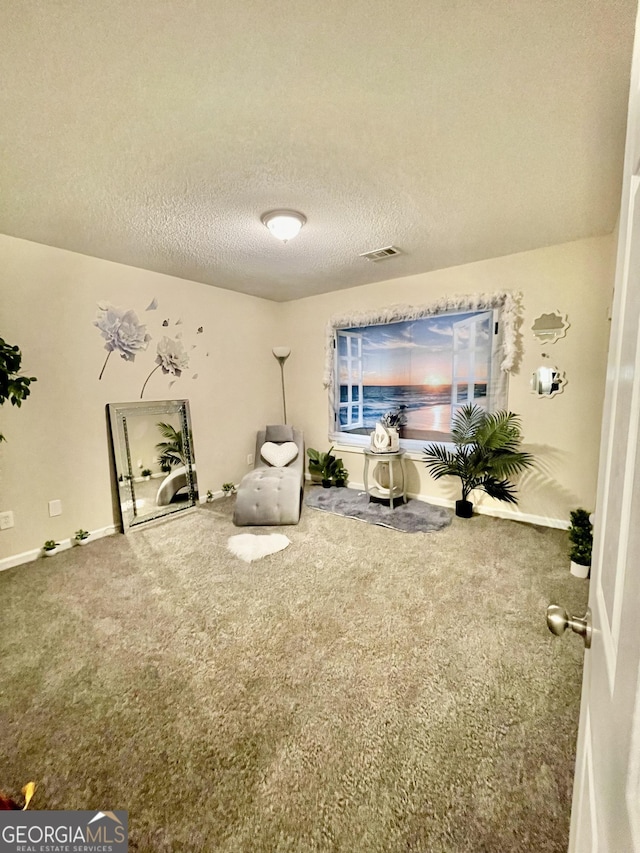 sitting room featuring baseboards, carpet flooring, visible vents, and a textured ceiling