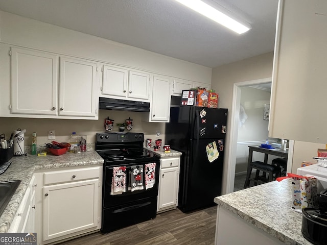 kitchen with ventilation hood, dark wood-style flooring, white cabinets, and black appliances