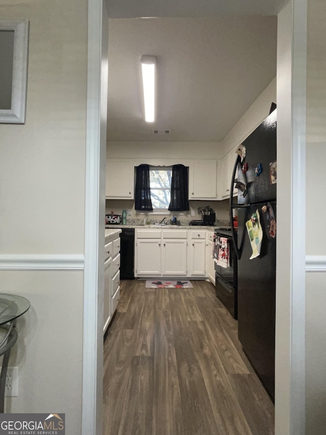 kitchen with visible vents, dark wood-style floors, light countertops, black appliances, and white cabinetry