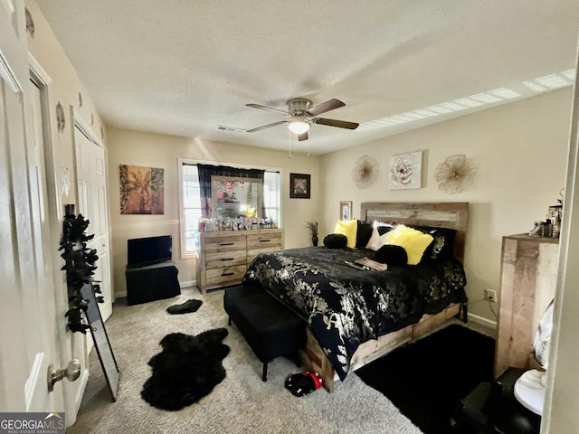 bedroom with baseboards, visible vents, a ceiling fan, a textured ceiling, and carpet flooring