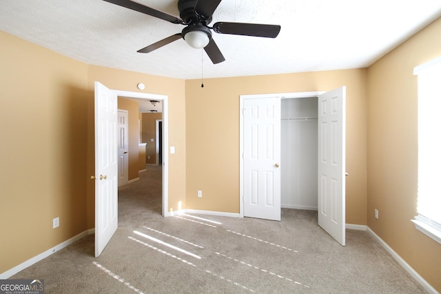 unfurnished bedroom featuring ceiling fan, a closet, carpet flooring, and baseboards