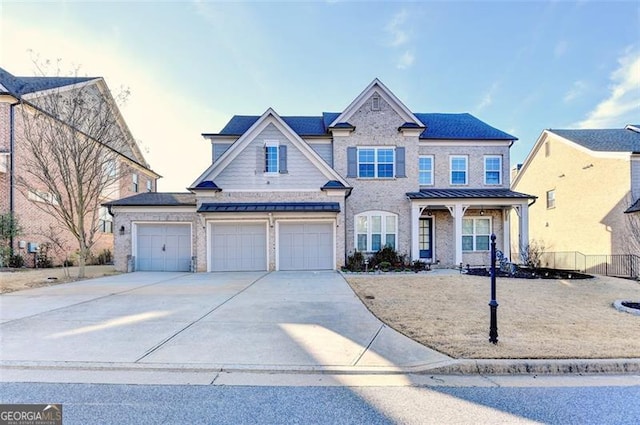 view of front of property featuring metal roof, a garage, fence, driveway, and a standing seam roof