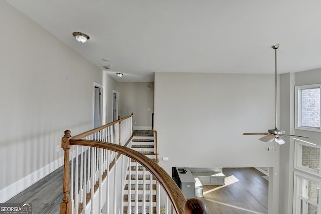 staircase featuring ceiling fan, wood finished floors, and baseboards