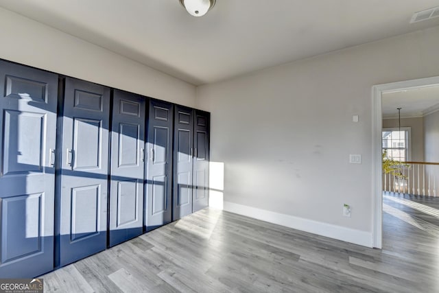 empty room with visible vents, baseboards, and wood finished floors