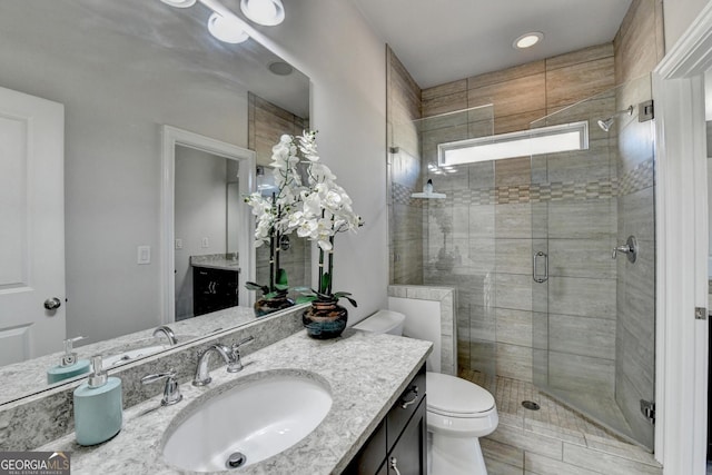 full bath with toilet, a shower stall, and vanity