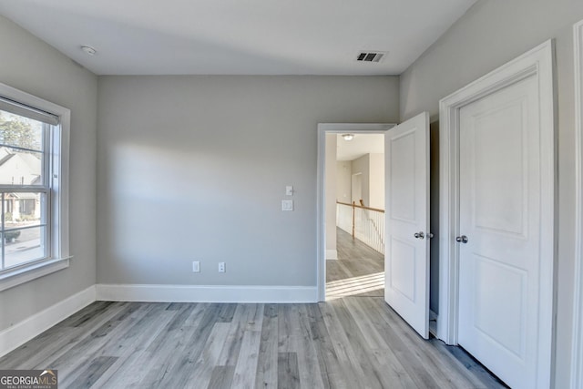 unfurnished bedroom featuring light wood finished floors, baseboards, and visible vents