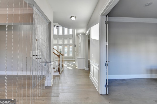 entryway with crown molding, stairway, a ceiling fan, wood finished floors, and baseboards