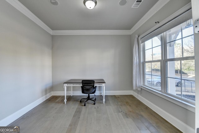 unfurnished office with visible vents, crown molding, baseboards, and wood finished floors