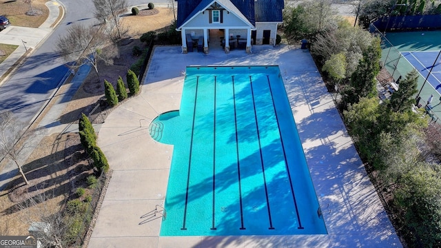 outdoor pool with a patio and fence