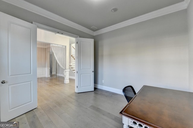 unfurnished office featuring baseboards, visible vents, light wood-style flooring, and crown molding