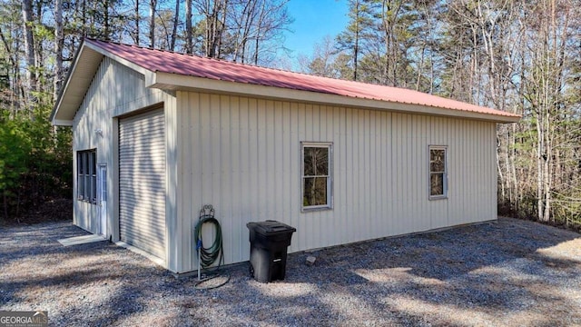 view of side of home featuring metal roof and an outbuilding