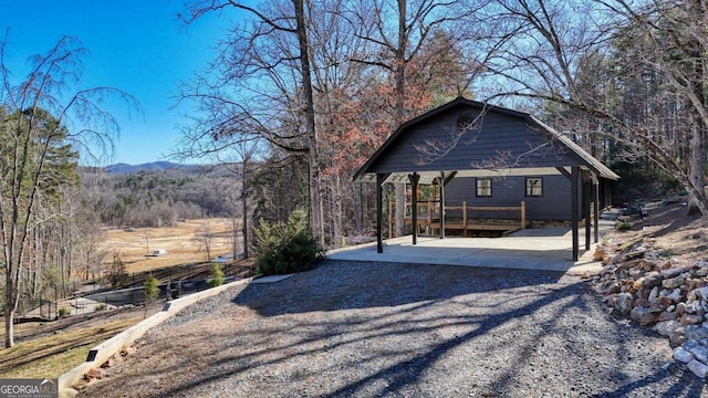 exterior space featuring driveway and a view of trees