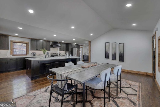 dining space with lofted ceiling, recessed lighting, wood finished floors, and baseboards