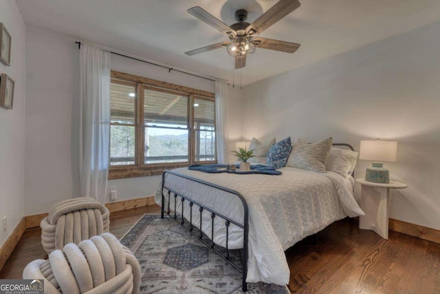 bedroom with ceiling fan, baseboards, and wood finished floors