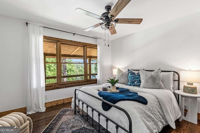 bedroom featuring a ceiling fan, baseboards, and wood finished floors