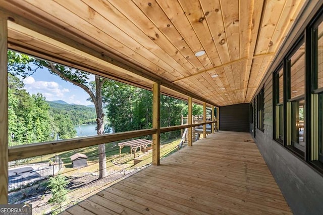 deck with a water view and a view of trees