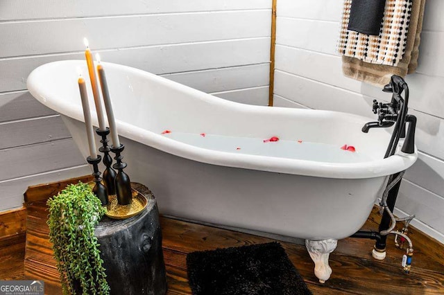 full bathroom with a freestanding bath and wood finished floors