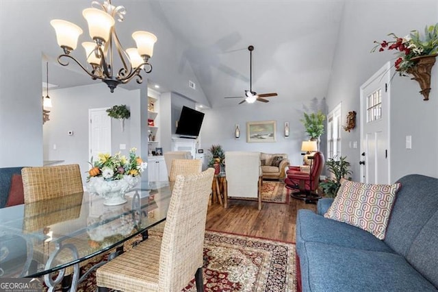 dining room with lofted ceiling, wood finished floors, and ceiling fan with notable chandelier