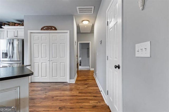 kitchen with visible vents, white cabinets, stainless steel fridge with ice dispenser, dark countertops, and dark wood-style floors