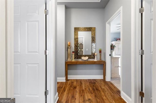 corridor featuring dark wood finished floors and baseboards