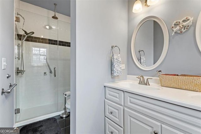 full bathroom with double vanity, a sink, and a shower stall