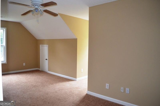 additional living space featuring a ceiling fan, lofted ceiling, carpet flooring, and baseboards