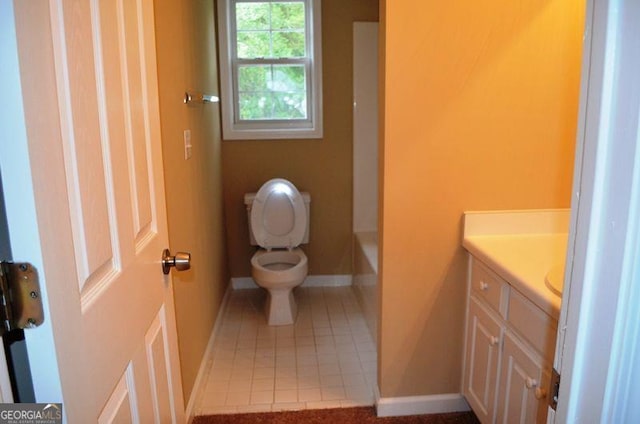 bathroom with toilet, a bathing tub, vanity, baseboards, and tile patterned floors