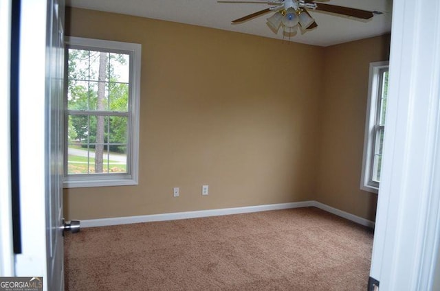 empty room featuring carpet, a ceiling fan, and baseboards