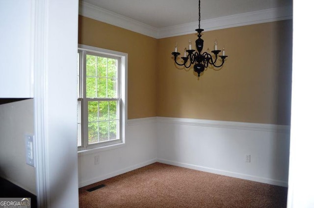 carpeted spare room featuring baseboards, visible vents, a notable chandelier, and ornamental molding