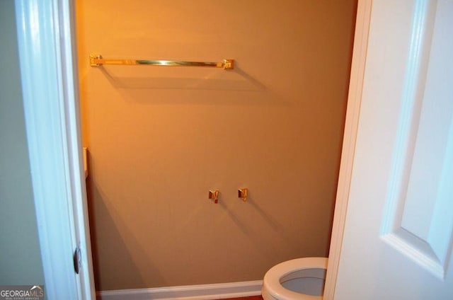 bathroom featuring baseboards and toilet