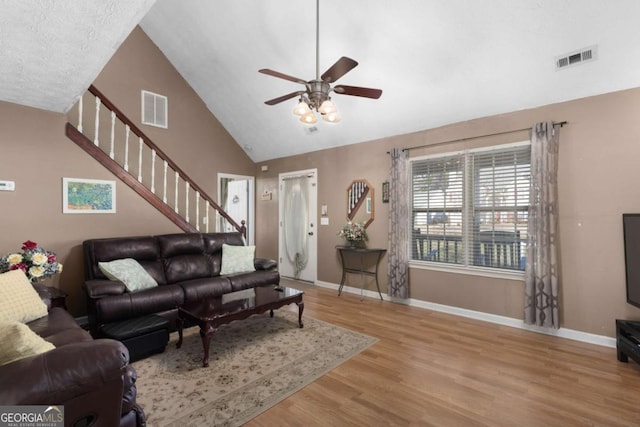 living room with visible vents, stairway, baseboards, and wood finished floors