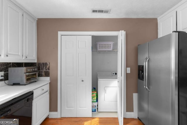 kitchen with washer / dryer, visible vents, white cabinets, dishwasher, and stainless steel refrigerator with ice dispenser