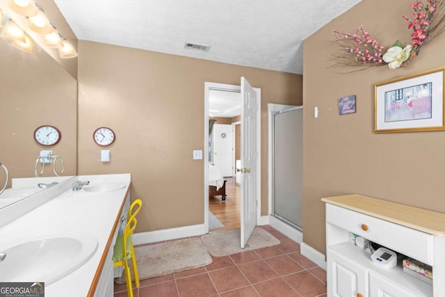 bathroom featuring a sink, a shower stall, and tile patterned floors