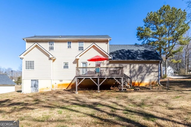 rear view of house with a deck, a lawn, and stairway