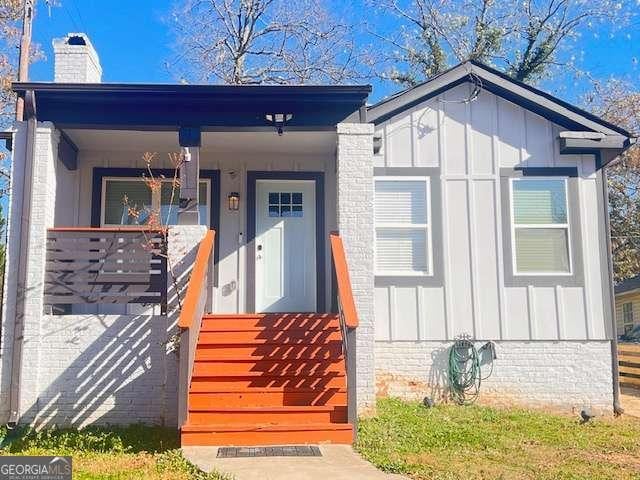 view of exterior entry with a chimney and board and batten siding