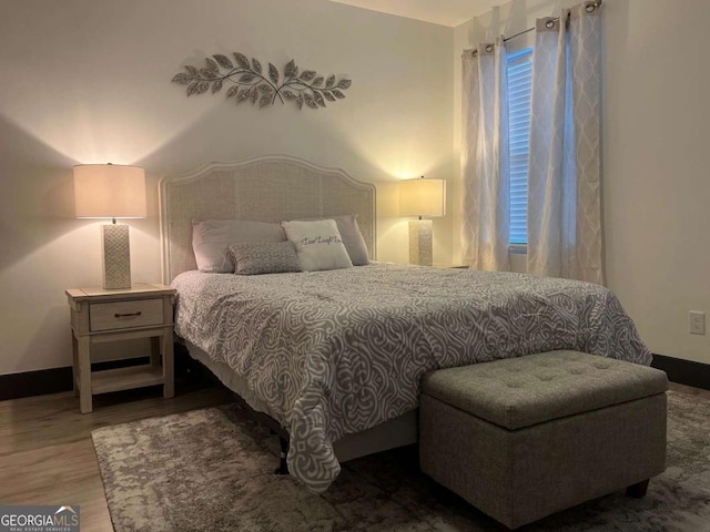 bedroom featuring baseboards and wood finished floors