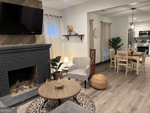 interior space featuring a brick fireplace and light wood-style flooring