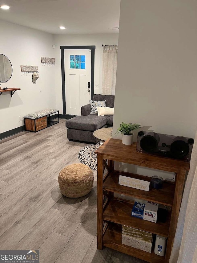 living area featuring baseboards, wood finished floors, and recessed lighting