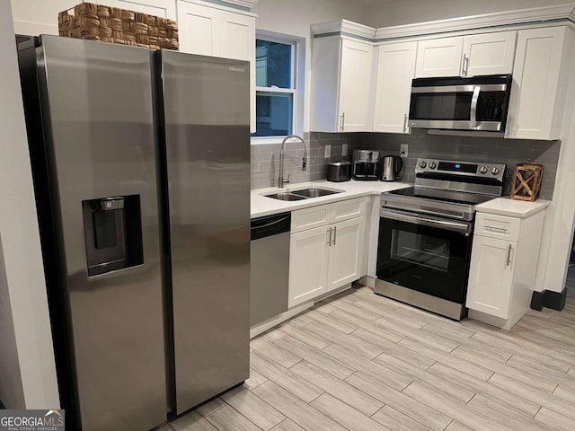 kitchen featuring stainless steel appliances, wood finish floors, a sink, and decorative backsplash