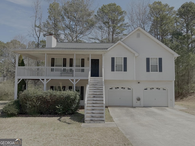 view of front of property featuring a chimney, a porch, concrete driveway, stairway, and a garage