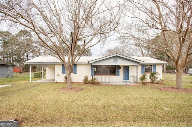 ranch-style house with covered porch, fence, metal roof, a carport, and a front lawn