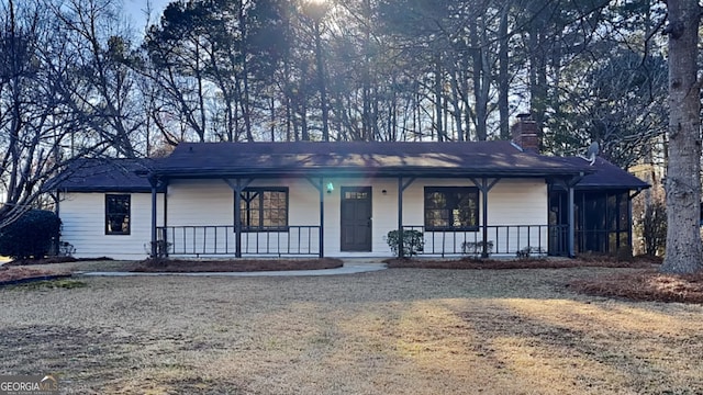 view of front of house featuring covered porch and a chimney