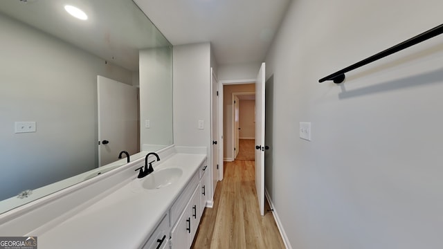 bathroom with vanity, baseboards, and wood finished floors